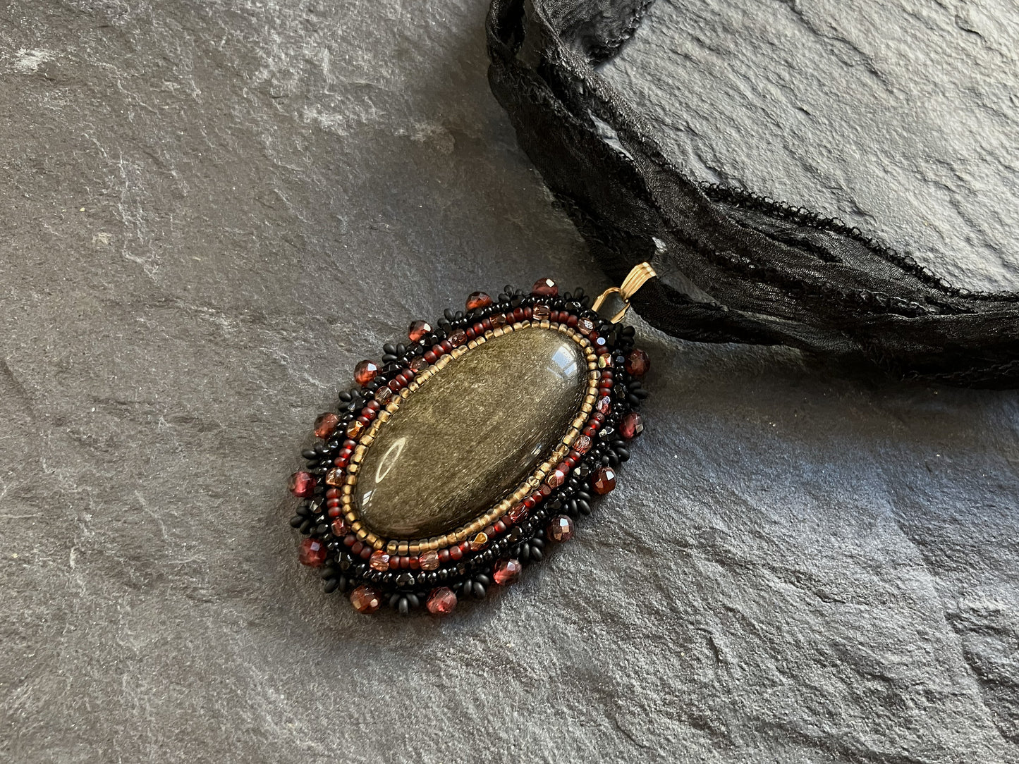Golden onyx necklace pendant with garnet beads
