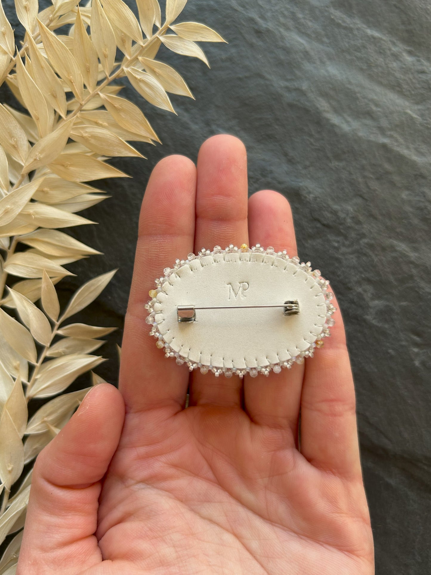 Howlite brooch with rutilated quartz