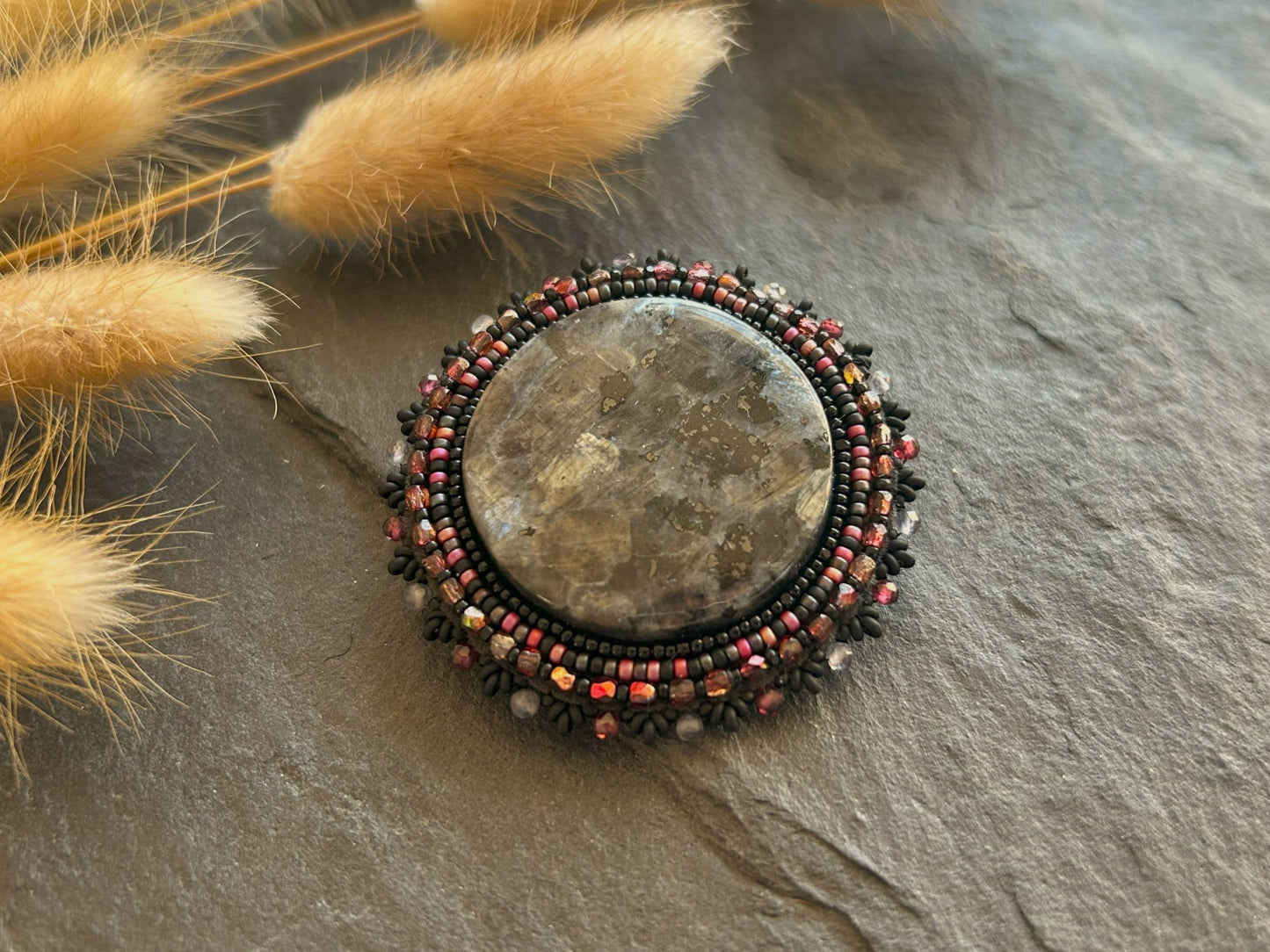 Larvikite brooch with water sapphire and garnet
