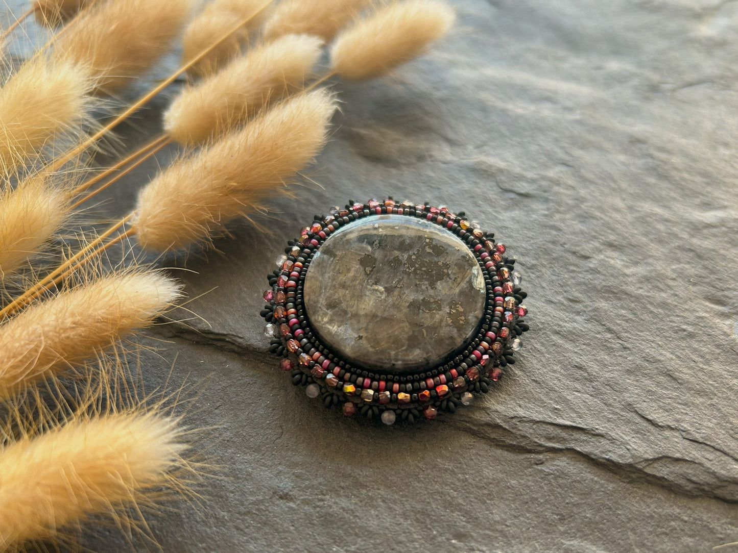 Larvikite brooch with water sapphire and garnet