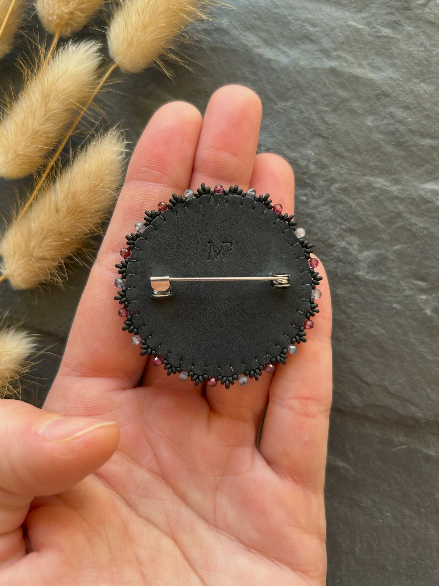 Larvikite brooch with water sapphire and garnet